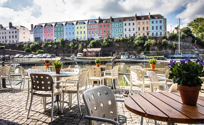 Outside seating and view of colourful houses at Riverstation