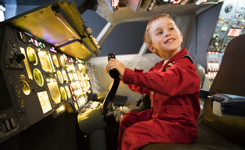 Boy sat in the cockpit of a plane at Aerospace Bristol