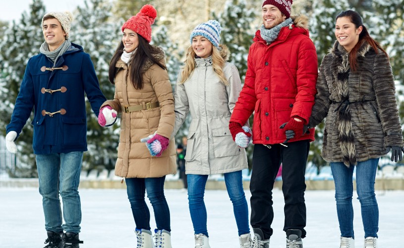 Group hold hands as they ice skate