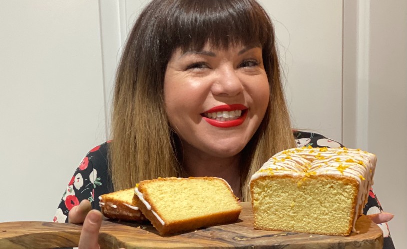 Bake off star Briony May Williams holding lemon drizzle loaf cake on wooden chopping board